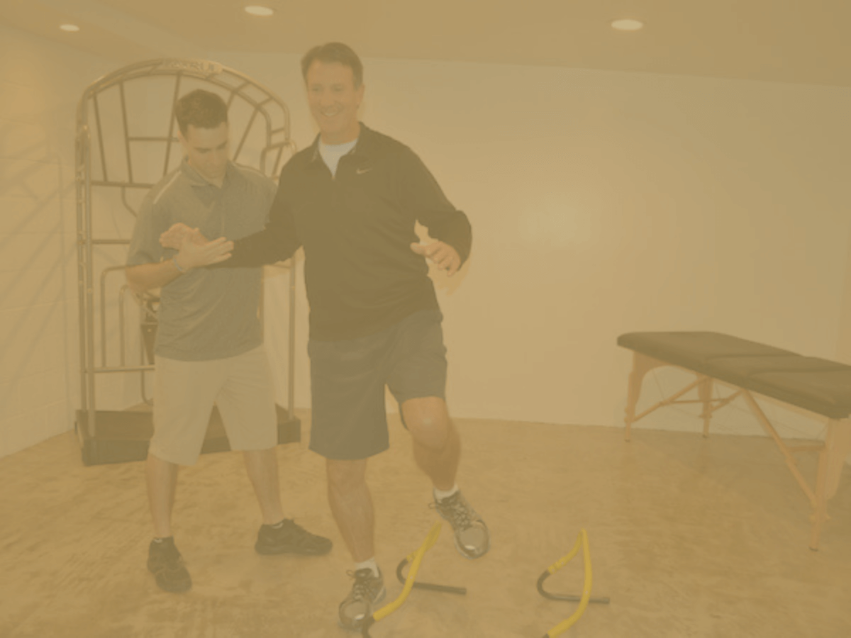 Male physical therapist preforming balance training with an elderly man