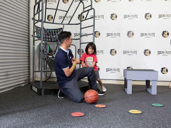 Male physical therapist talking to a child with a red shirt