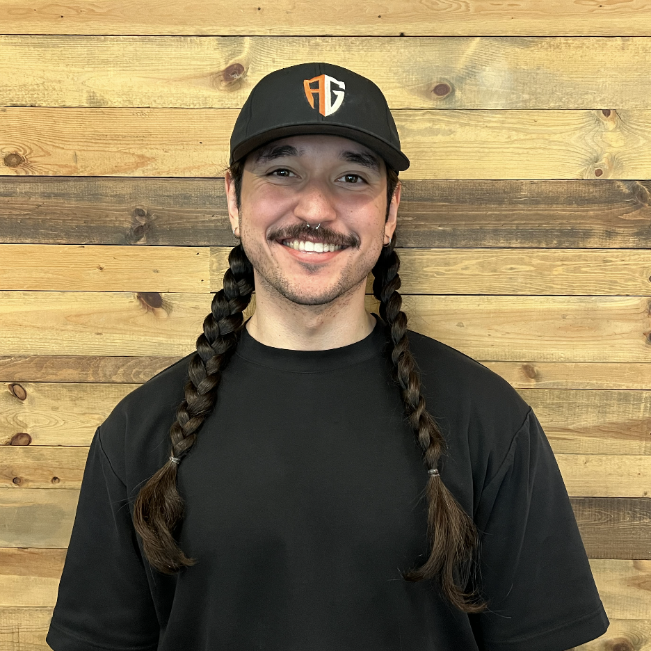 Man with facial hair and red shirt smiling